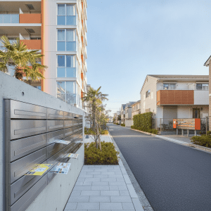 現代的なマンションと住宅が並ぶ街並みで、的を絞ったポスティングを示す。